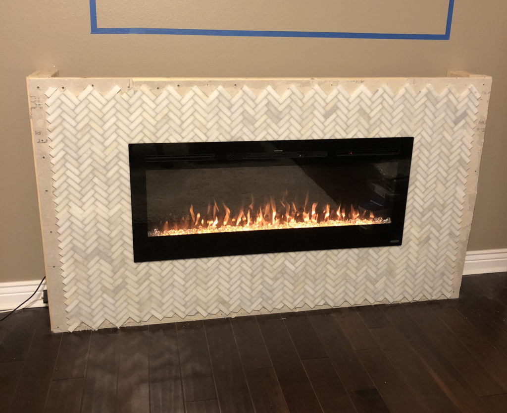 Mosaic tile fireplace mantle around electric fireplace insert